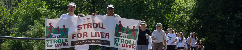 A lineup of Stroll for Liver participants walk holding a large Stroll for Liver banner