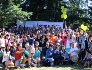 A large group of Stroll participants pose in front of the Stroll for Liver banner