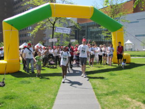 Stroll for Liver participants walk through a green and yellow archway to start the walk