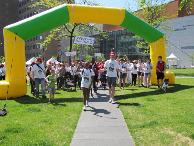 Stroll for Liver participants walk through a green and yellow archway to start the walk