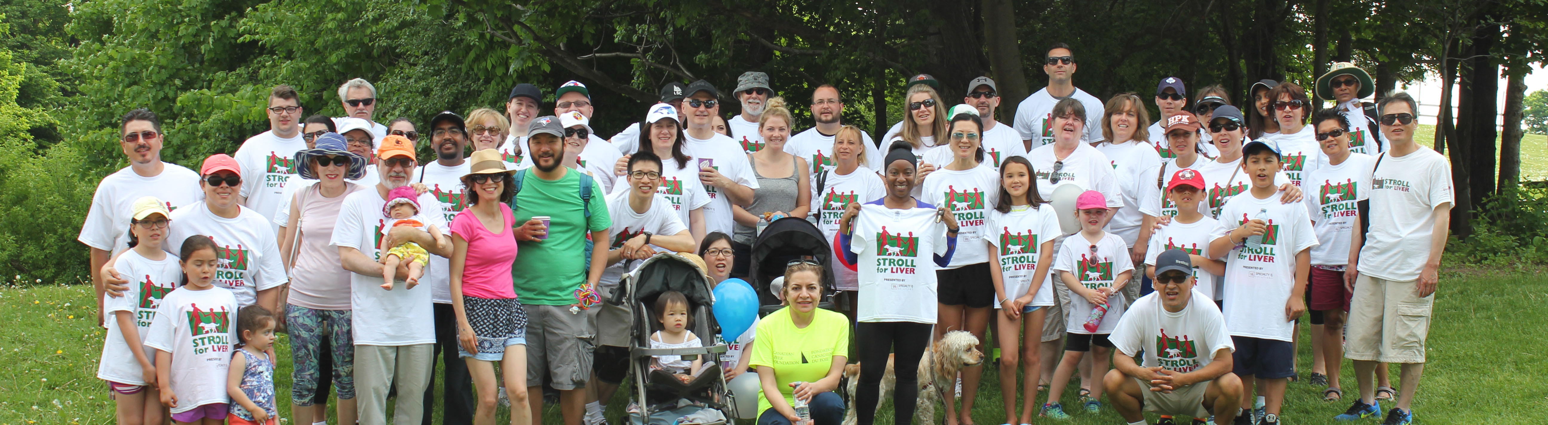 A group of Stroll for Liver participants pose with each other on a grassy field