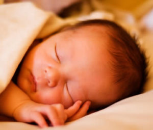 A newborn baby sleeps peacefully