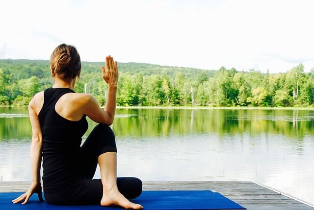 A woman doing yoga by the lake; a great form of exercise