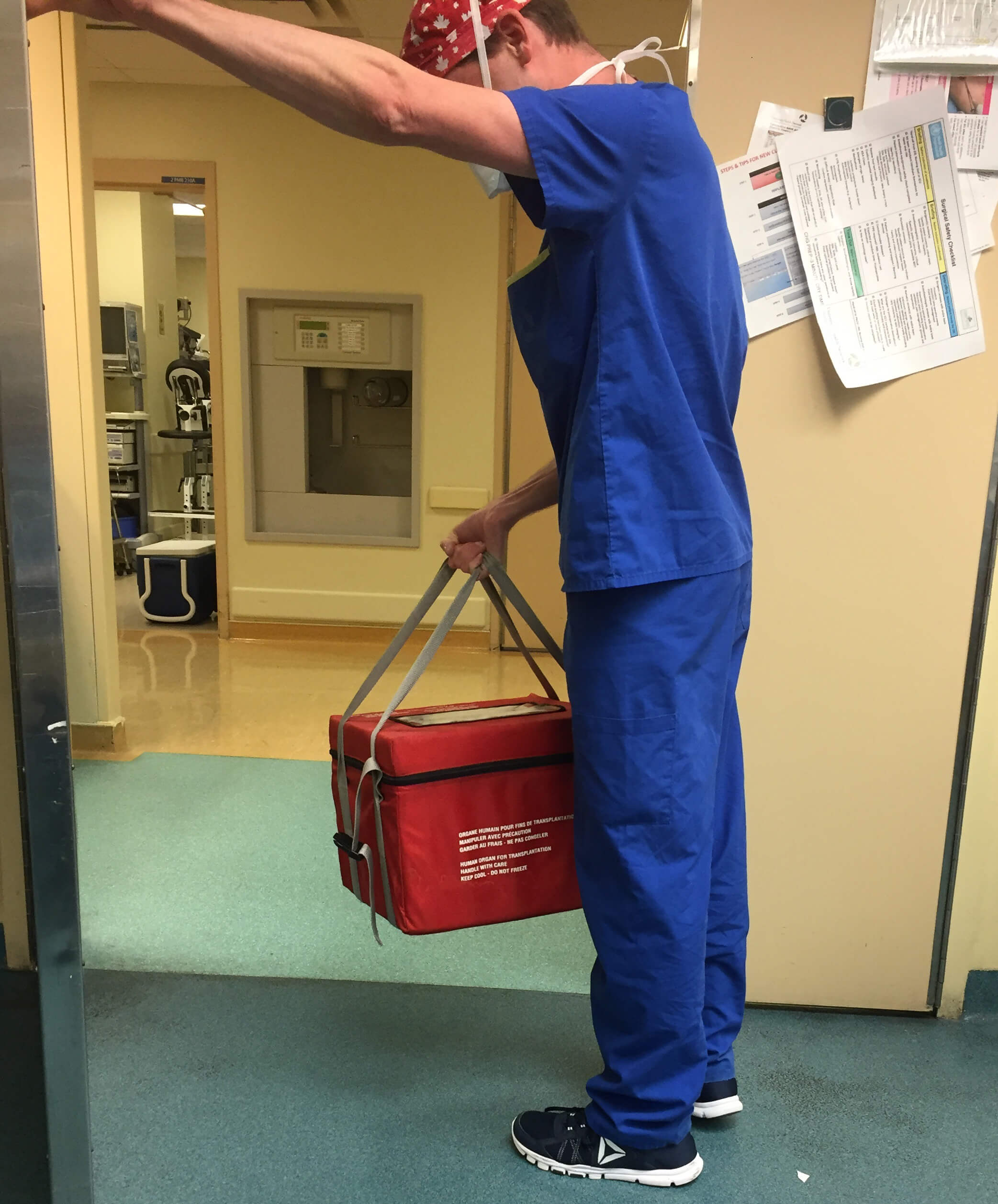 A doctor with his face hidden carries a cooler bag with a piece of Heather's liver in it. The doctor will travel through a tunnel that connects Toronto General Hospital to SickKids hospital to deliver the liver.