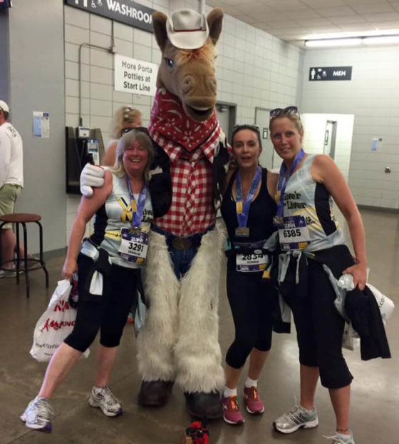 Debralee, Donna and Marla pose with a horse mascot at the Calgary marathon