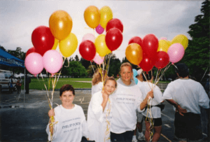 Three children are volunteering for the Canadian Liver Foundation by selling balloons. They are wearing matching CLF t-shirts for the event they were attending.