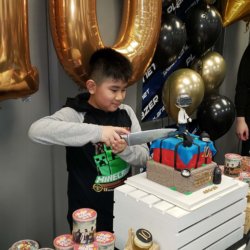 Little heroes birthday party: little boy cutting birthday cake