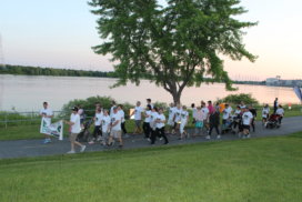 group of participants walking along the water