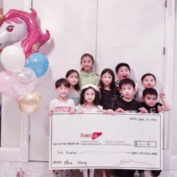 Little heroes birthday party: group of children holding large cheque for CLF