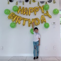 Little heroes birthday party: little boy under a happy birthday sign