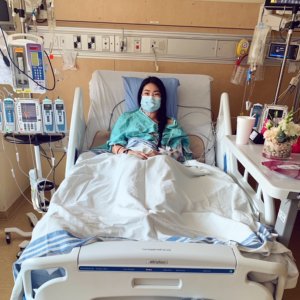 Woman laying in a hospital bed looking at the camera
