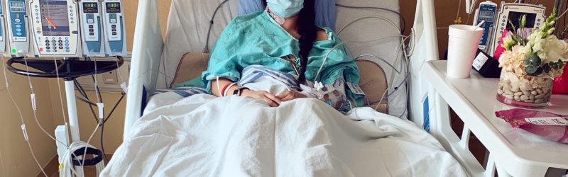 Woman laying in a hospital bed looking at the camera